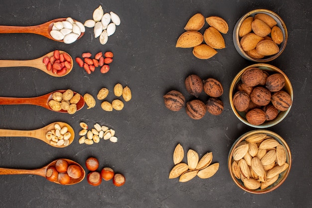 Draufsicht auf frische Nüsse, Erdnüsse und andere Nüsse auf dunkler Oberfläche