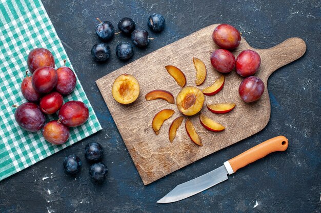 Draufsicht auf frische Pflaumen ganz weich und saftig geschnitten auf dunkelgrauem, fruchtfrischem Vitaminsommer