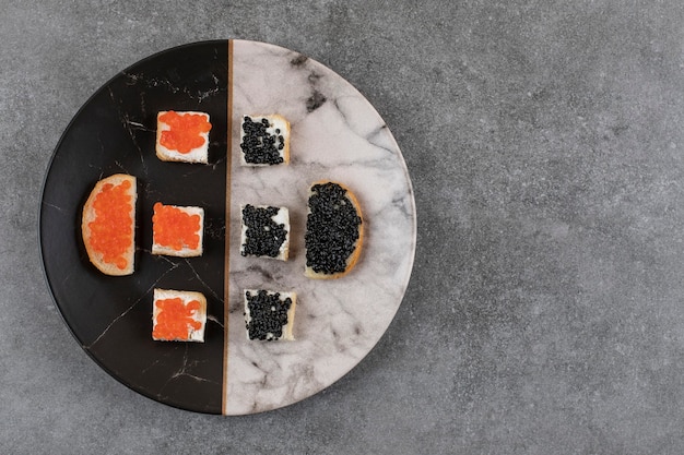 Kostenloses Foto draufsicht auf frische sandwiches mit kaviar auf buntem teller