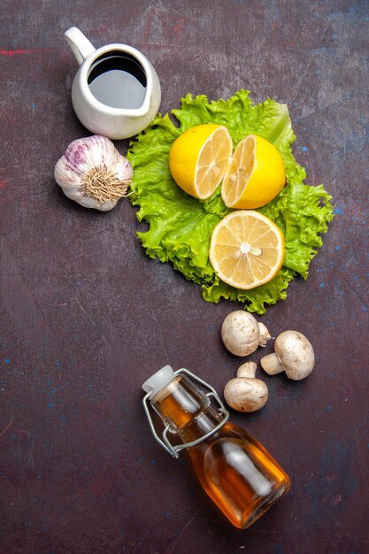 Draufsicht auf frische Zitronenscheiben mit grünem Salat auf dunklem