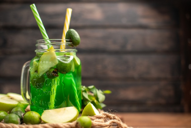 Draufsicht auf frischen leckeren Fruchtsaft, serviert mit Apfel und Feijoas auf einem Holzbrett