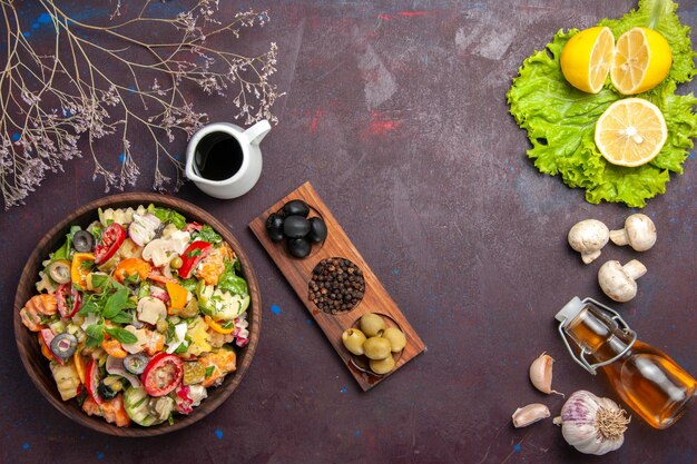 Draufsicht auf frisches Gemüse. Salat mit Oliven und Zitronenscheiben auf Schwarz