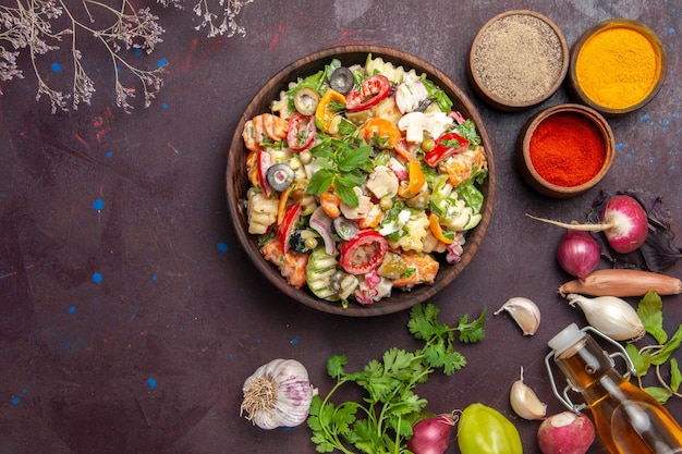 Draufsicht auf frisches Gemüse. Salat mit verschiedenen Gewürzen auf Schwarz