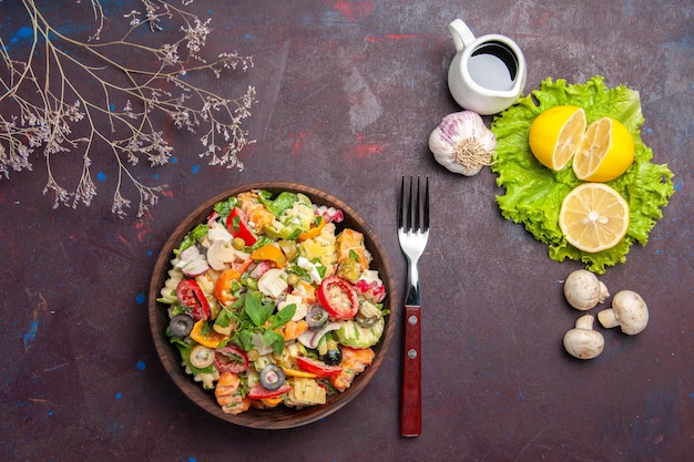 Draufsicht auf frisches Gemüse. Salat mit Zitronenscheiben und grünem Salat auf schwarzem Tisch