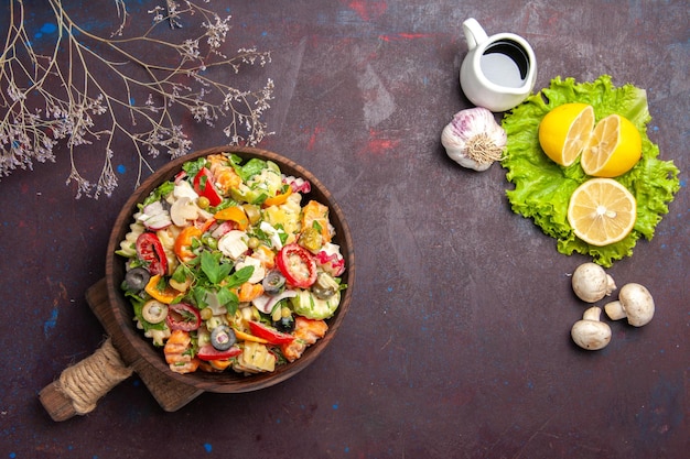 Draufsicht auf frisches Gemüse. Salat mit Zitronenscheiben und grünem Salat auf schwarzem Tisch