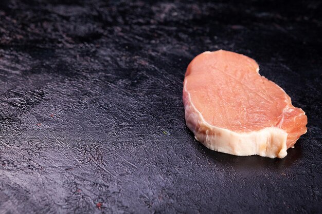 Draufsicht auf frisches rohes Fleisch auf schwarzem Holztisch. Gourmet-Essen und frische Rohkost