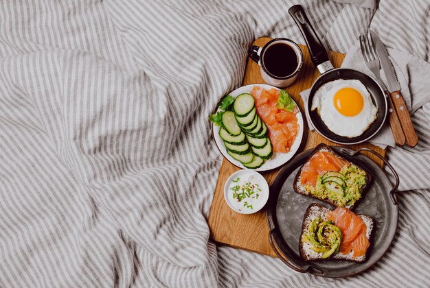 Draufsicht auf Frühstücksbrötchen auf Bett mit Spiegelei und Toast mit Kopierraum