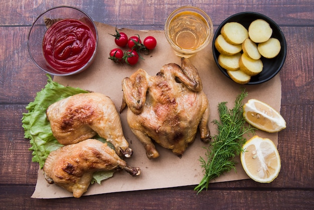 Draufsicht auf ganzes Hähnchen und Bein zum Abendessen am Schreibtisch