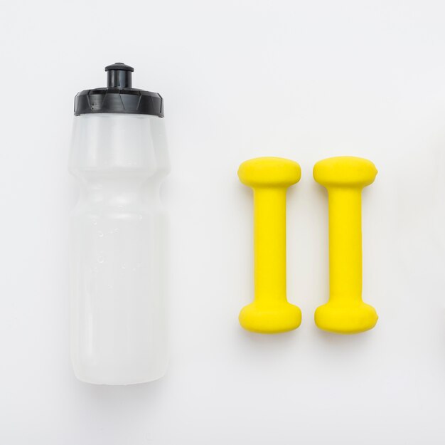 Draufsicht auf gelbe Gewichte und Wasserflasche