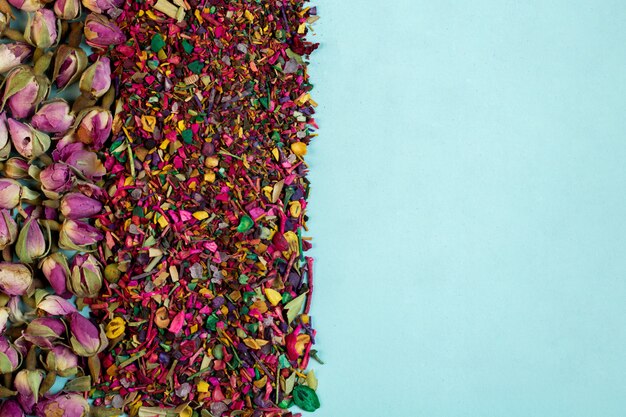 Draufsicht auf gemischte Kräuterteeblüten Rosenblätter getrocknete Rosenknospen und Kräuter auf Blau