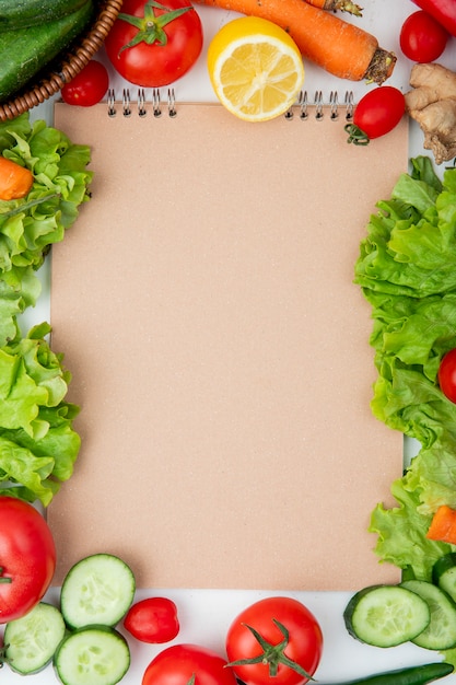 Draufsicht auf Gemüse als Salat, Gurke, Karotte und andere mit Zitrone und Kopierraum