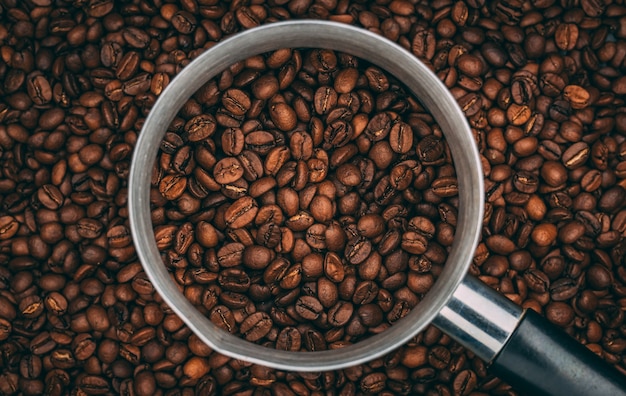 Draufsicht auf geröstete Kaffeebohnen in Stahltasse