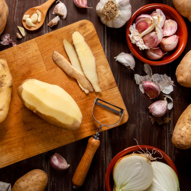 Draufsicht auf geschälte Kartoffeln mit Knoblauch