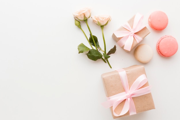 Draufsicht auf Geschenke mit Macarons und Rosen
