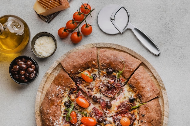 Kostenloses Foto draufsicht auf geschnittene pizza mit parmesan und ausstecher