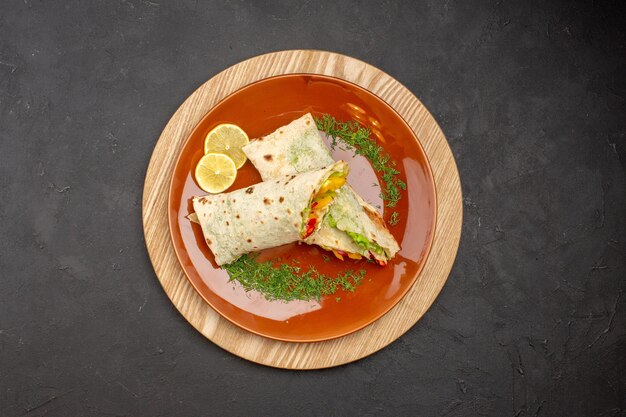 Draufsicht auf geschnittenes shaurma köstliches Fleischsandwich in der Platte auf Schwarz