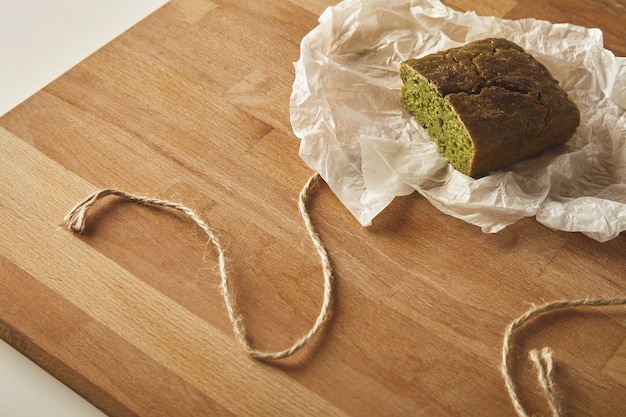 Draufsicht auf gesundes Diät-Spinatbrot lokalisiert auf Holzbrett auf Tisch in Bastelpapier