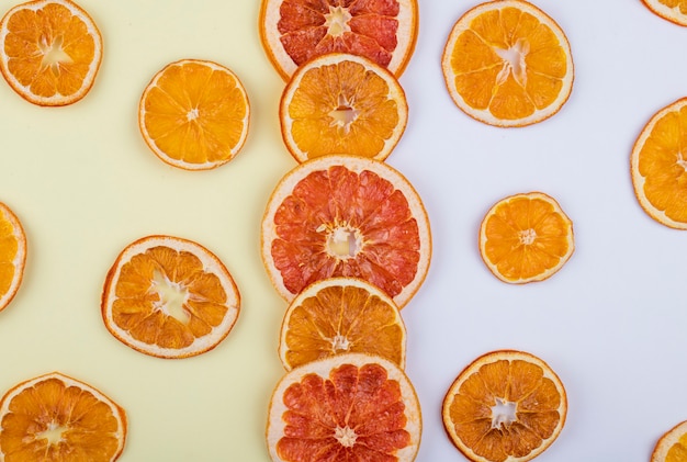 Draufsicht auf getrocknete Orangen- und Grapefruitscheiben angeordnet auf weißem Hintergrund