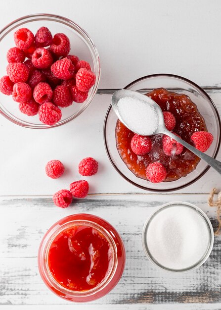 Draufsicht auf Glas mit Himbeermarmelade und Früchten