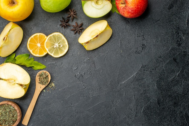 Draufsicht auf grüngelb geschnittene und ganze frische Äpfel auf der rechten Seite auf dunklem Hintergrund