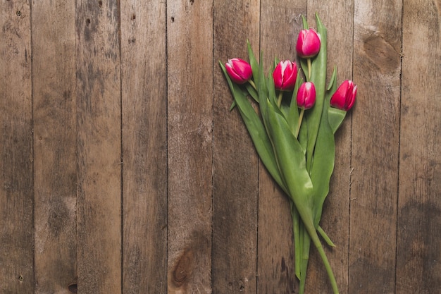 Draufsicht auf Holztisch mit niedlichen Tulpen