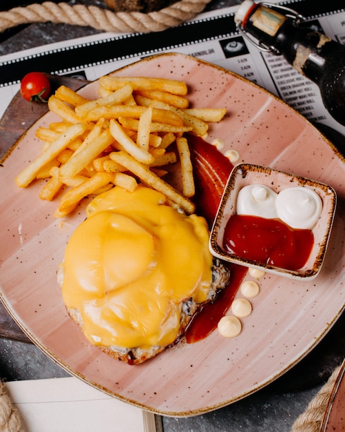 Draufsicht auf Hühnchenpastetchen mit geschmolzenem Käse, serviert mit Pommes Frites Ketchup und Mayonnaise