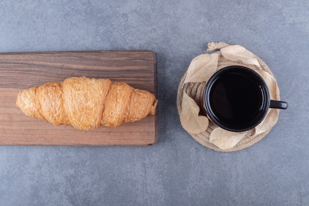 Draufsicht auf kaffee und croissants. klassisches französisches frühstück auf grauem hintergrund.