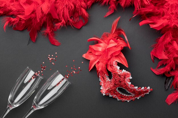 Draufsicht auf Karnevalsmasken mit Federn und Champagnergläsern