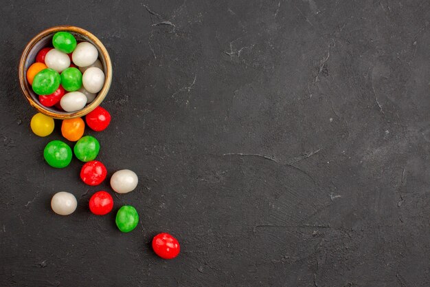 Draufsicht auf kleine bunte Bonbons auf Schwarz