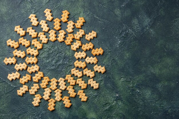 Draufsicht auf kleine gesalzene Cracker auf dunkler Oberfläche