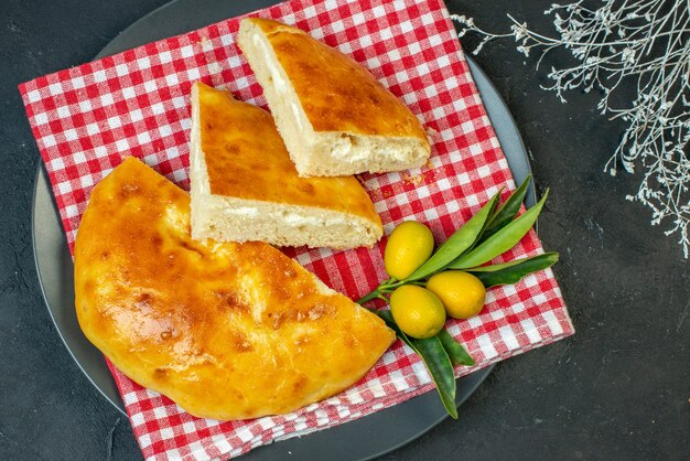 Draufsicht auf köstliche Brotkumquats mit Stiel auf dunkler Oberfläche