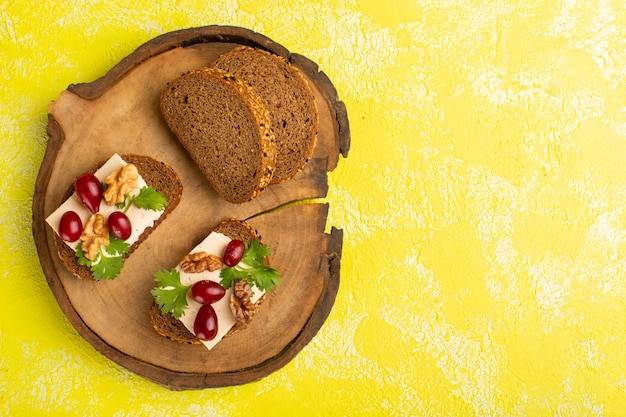 Draufsicht auf köstliche Brottoasts mit Hartriegelkäse auf der gelben Oberfläche