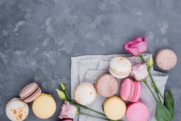 Kostenloses Foto draufsicht auf köstliche macarons mit rosen und kopierraum