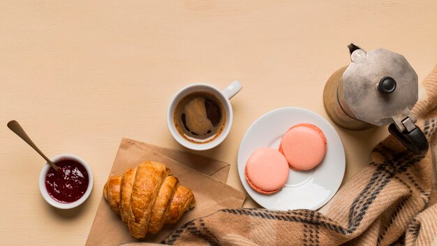 Draufsicht auf köstliche Macarons und Croissants