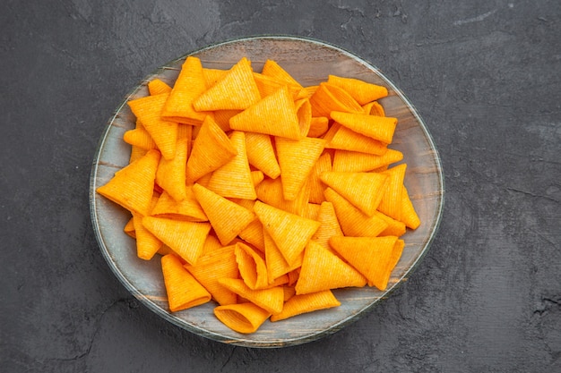 Draufsicht auf köstliche Snacks in einer blauen Schüssel auf dunklem Hintergrund