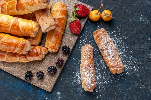 Draufsicht auf köstliche süße Armreifen mit Füllung lecker mit Früchten auf dunklem, backen Kuchen Keks Zucker süßes Dessert gebacken