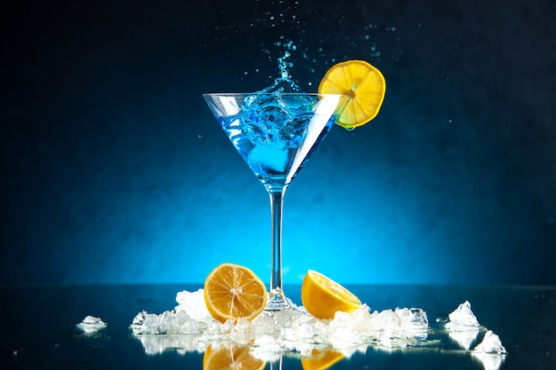 Draufsicht auf köstlichen Cocktail in einem Glasbecher, serviert mit Zitronenscheibeneis auf blauem Hintergrund