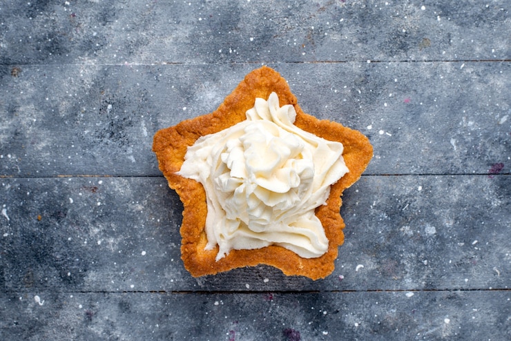 Kostenlose Foto draufsicht auf köstlichen gebackenen kuchenstern geformt mit weißer leckerer sahne innen auf hellem schreibtisch, kuchen backen zucker süßer sahne-tee