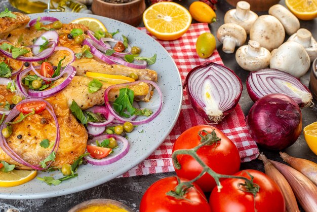 Draufsicht auf köstliches Abendessen gebratenes Hühnergericht mit verschiedenen Gewürzen und Lebensmitteln Knoblauch Ölflasche Zitronenzwiebeln Pilze Kumquats