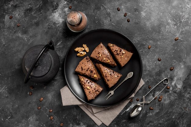 Draufsicht auf Kuchenstücke auf Teller mit Teekanne und Kaffeebohnen