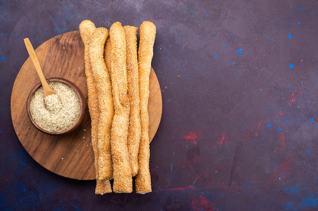 Kostenloses Foto draufsicht auf langes brötchenbrot, das lange auf der dunklen oberfläche gebildet wurde