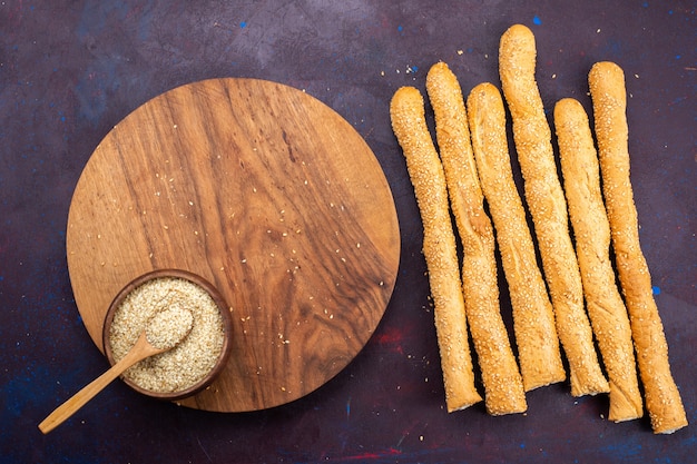 Kostenloses Foto draufsicht auf langes gebackenes brötchen des langen brötchens auf der dunklen oberfläche