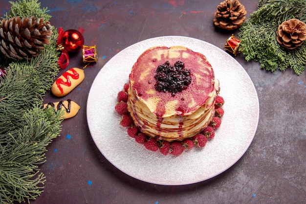 Draufsicht auf leckere Geleepfannkuchen mit frischen Erdbeeren auf Dunkelheit