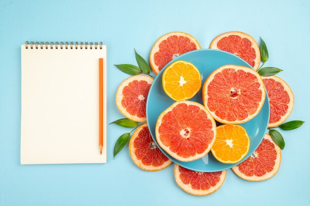 Draufsicht auf leckere Grapefruits-Fruchtscheiben auf der blauen Oberfläche