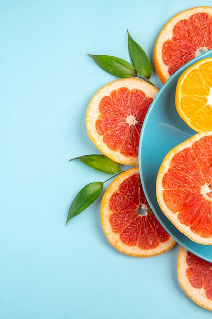 Kostenloses Foto draufsicht auf leckere grapefruits-fruchtscheiben auf der blauen oberfläche