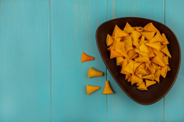 Draufsicht auf leckere kegelförmige gebratene Maissnacks auf einer Schüssel mit Kopierraum