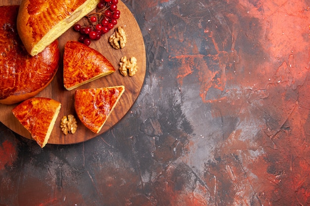 Draufsicht auf leckere Kuchen, die mit roten Beeren geschnitten werden