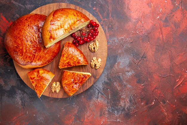 Draufsicht auf leckere Kuchen, die mit roten Beeren geschnitten werden