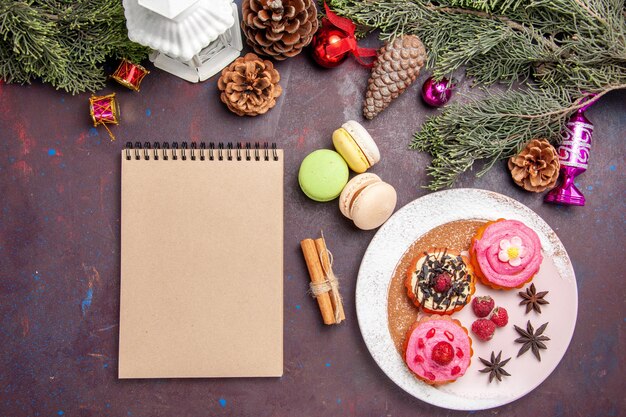 Draufsicht auf leckere Kuchen mit französischen Macarons auf Schwarz