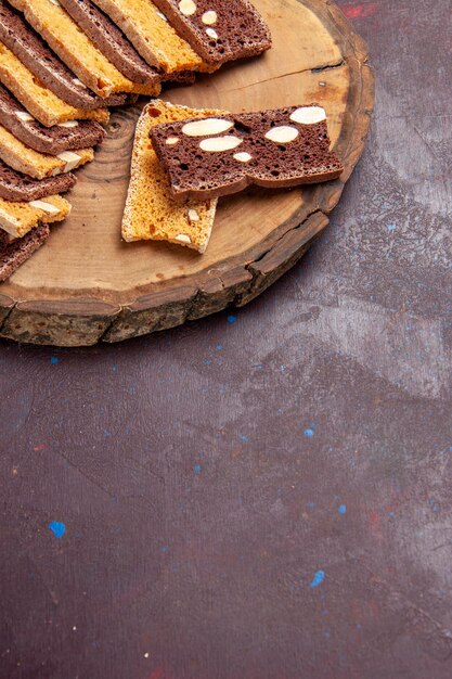 Draufsicht auf leckere Kuchenscheiben mit Nüssen auf Schwarz